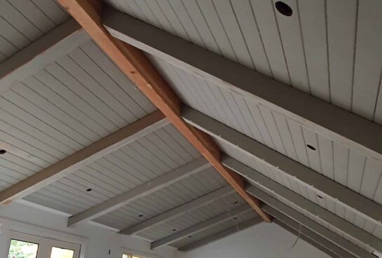 custom angled large gray wood tongue and groove (TNG) ceiling with beam